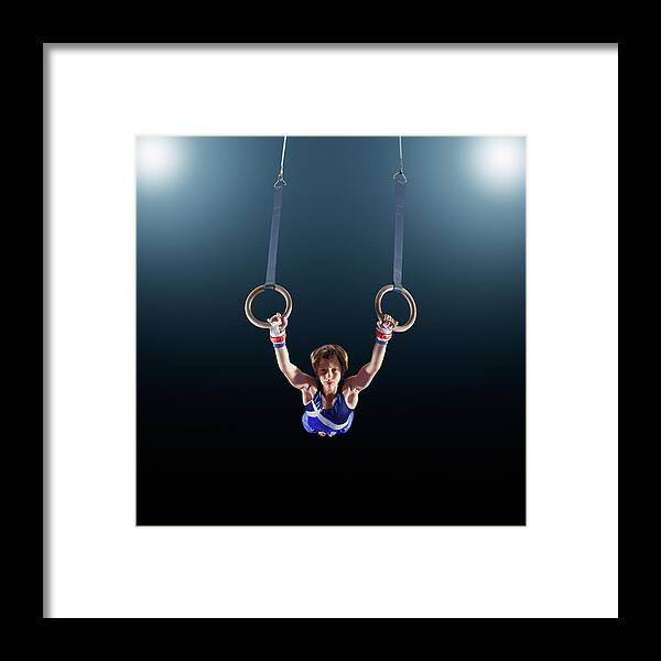 Focus Framed Print featuring the photograph Male Gymnast Performing On Rings by Robert Decelis Ltd
