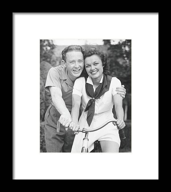 Young Men Framed Print featuring the photograph Man Embracing Woman Sitting On Bike by George Marks