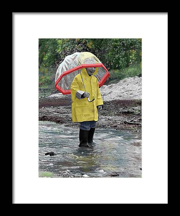 Child In Rain Gear With Umbrella Playing In Puddle. Framed Print featuring the photograph P091-03 by Nora Hernandez
