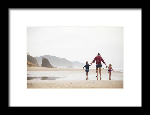 Free Framed Print featuring the photograph Rear View Of Mother Walking On Beach With Her Two Young Children. by Cavan Images