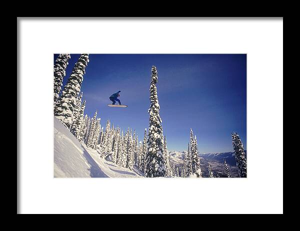 People Framed Print featuring the photograph Snowboarding Jumping Through Air by Comstock