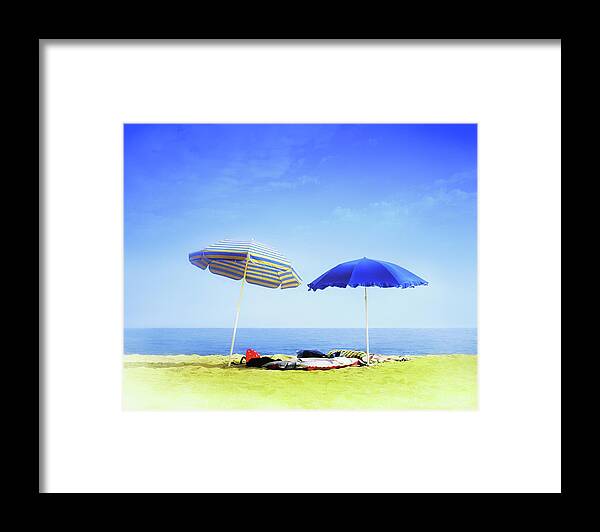 Empty Framed Print featuring the photograph Two Sunshades Over Clothes, Towels And by Gandee Vasan