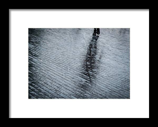 Silhouette Framed Print featuring the photograph Walking shadow of an unrecognised person walking on wet streets by Michalakis Ppalis