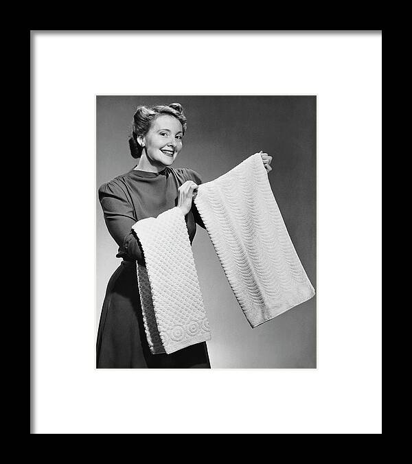 Three Quarter Length Framed Print featuring the photograph Woman Holding Up Towels by George Marks