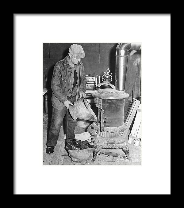 People Framed Print featuring the photograph Worker Filling Stove With Coals by Bettmann