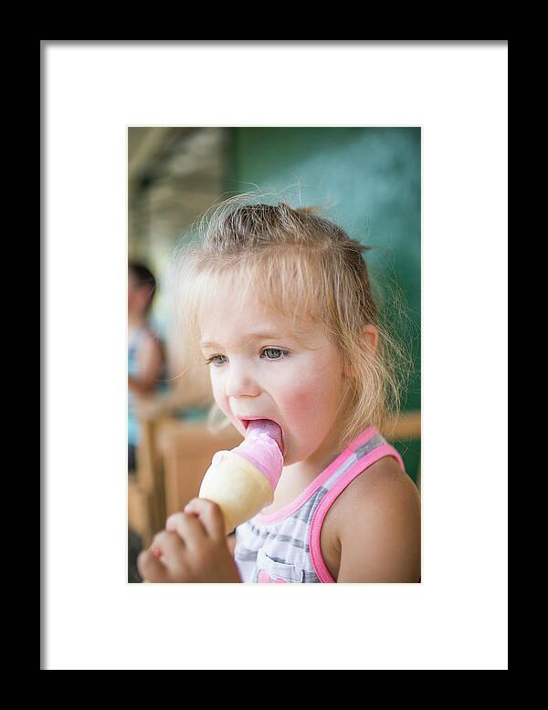 Ice Cream Framed Print featuring the photograph Young Cute Girl Happily Licking Pink Ice Cream On Summer Day. by Cavan Images
