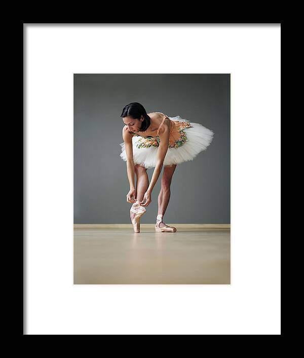 Ballet Dancer Framed Print featuring the photograph Young Female Ballerina Adjusting Ballet by Thomas Barwick