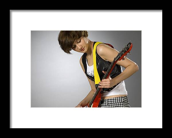 Expertise Framed Print featuring the photograph Close-up of a female guitarist playing a guitar #1 by Glowimages