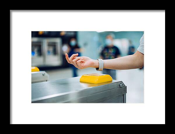 Subway Framed Print featuring the photograph Cropped shot of young Asian woman checking in at subway station using contactless payment for subway ticket via smartwatch #1 by D3sign