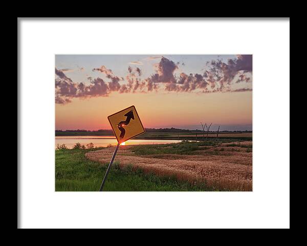 Sign Curve Scenic Landscape North Dakota Lake Syzygy Alignment Sun Pinhole Roadsign Hunting Bullet Humor Star Bullet Hole Shooting Shot Framed Print featuring the photograph Dodged a Bullet - curve in road sign with sunlight through bullet hole by Peter Herman