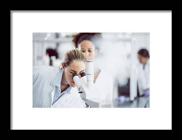 Expertise Framed Print featuring the photograph Female Scientist Looking Through A Microscope #1 by Sanjeri