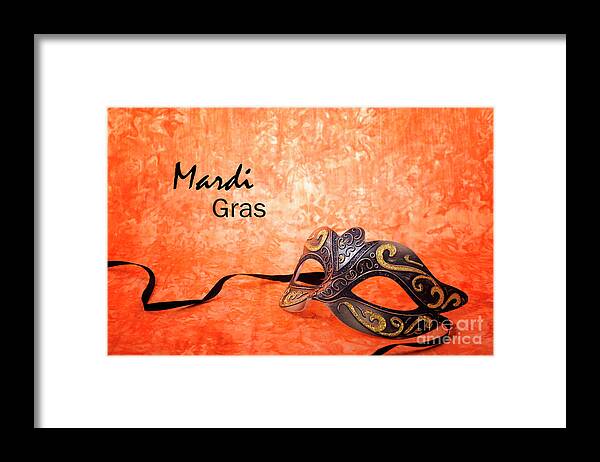 Black Framed Print featuring the photograph Mardi Gras mask on orange background. #1 by Milleflore Images