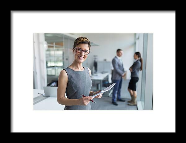 People Framed Print featuring the photograph Portrait of a young businesswoman in the office #1 by EmirMemedovski