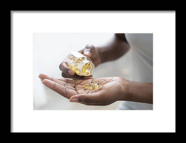 Vitamin Framed Print featuring the photograph Pouring capsules into hand #1 by Science Photo Library