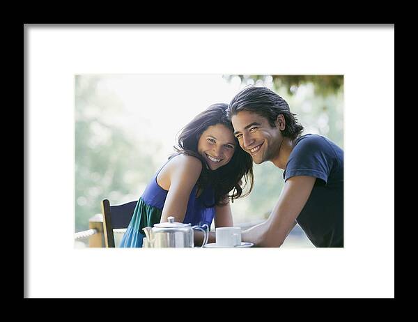 Young Men Framed Print featuring the photograph Smiling couple having tea outdoors #1 by Tom Merton
