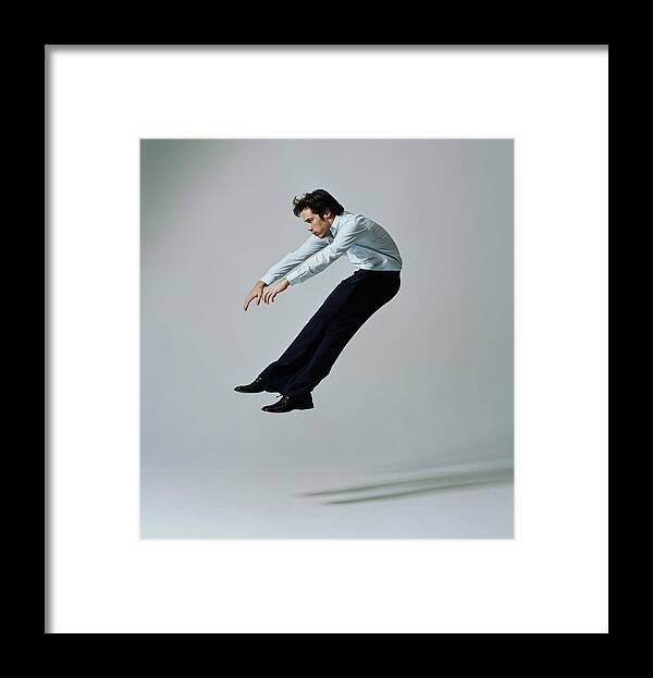 Human Arm Framed Print featuring the photograph Young businessman flying backwards, side view #1 by PM Images