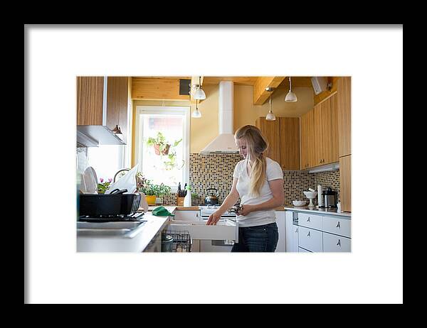 Working Framed Print featuring the photograph Young woman cleaning kitchen with green cleaning products #1 by Heshphoto