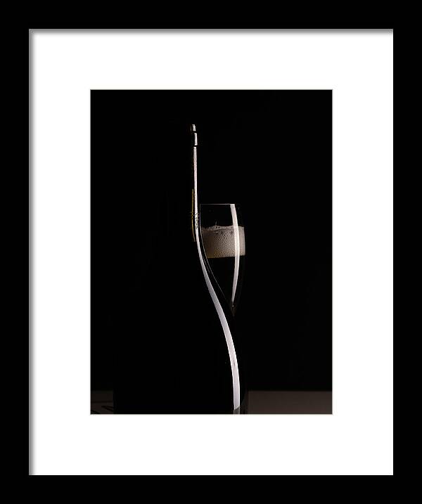 Red Wine Framed Print featuring the photograph Red sparking wine on a wineglass and black wine bottle. by Michalakis Ppalis