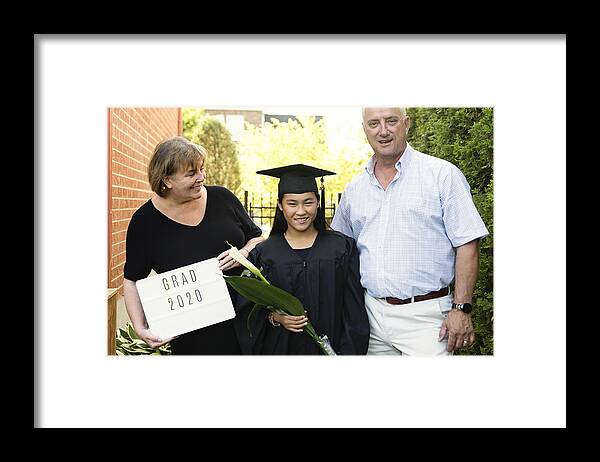 Asian And Indian Ethnicities Framed Print featuring the photograph Teenage girl graduation from primary school family portrait in backyard. #9 by Martinedoucet