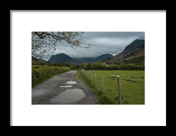 Dirt Road Framed Print featuring the photograph A dirt road to the Buttermere lake in Cumbria, England by Anges Van der Logt