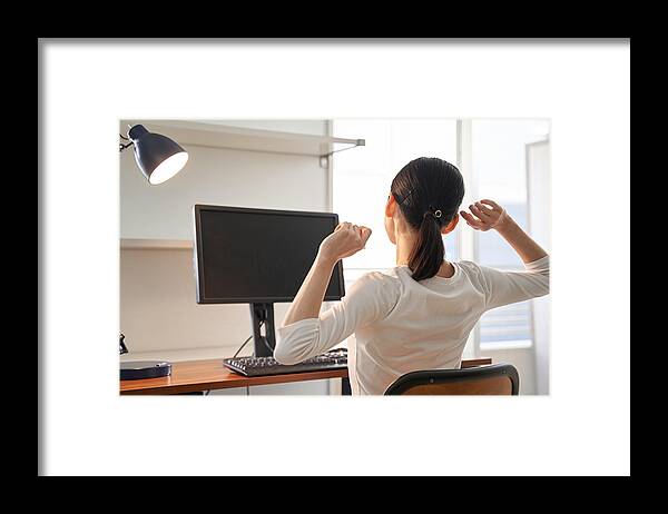 Working Framed Print featuring the photograph A plainclothes Japanese woman businesswoman taking a break from working from home by Kazuma Seki
