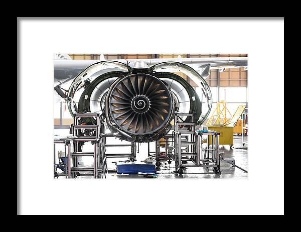Manufacturing Equipment Framed Print featuring the photograph Aircraft Jet engine maintenance in airplane hangar by Baranozdemir