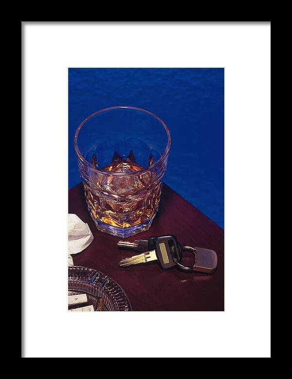 Punishment Framed Print featuring the photograph Alcoholic beverage next to car keys symbolizes drunk driving by Comstock