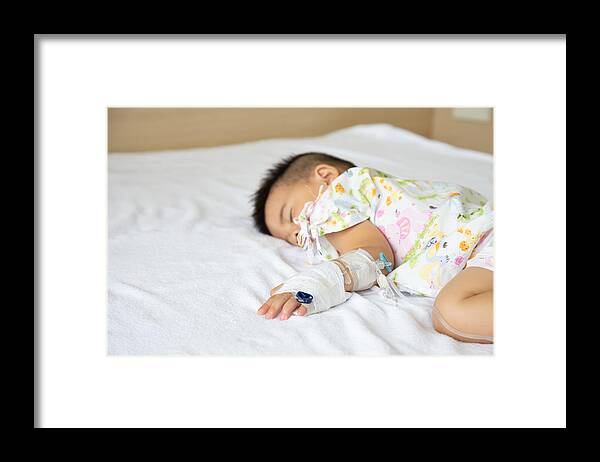 Allergy Medicine Framed Print featuring the photograph Asian baby boy sleeping on bed with infusion set at child department in the hospital. Children with infectious diseases IPD, Invasive Pneumococcal Disease concept. Infant model one year six months by Comzeal