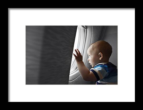 People Framed Print featuring the photograph Baby boy looking fascinated out of airplane window by Klaus Vedfelt
