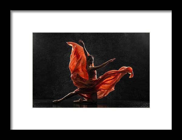 Ballet Dancer Framed Print featuring the photograph Ballerina. Silhouette photo of a young ballet dancer dressed in a long peach dress, pointe shoes with ribbons. The girl performs an graceful dance movement. Beautiful classic ballet. Ballet studios. by Anna Fedoseeva