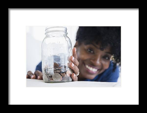 Coin Framed Print featuring the photograph Black woman saving coins in jar by JGI/Jamie Grill