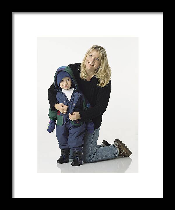Toddler Framed Print featuring the photograph Blonde Mom Kneels Behind Young Son Putting His Coat On With A Smile by Photodisc