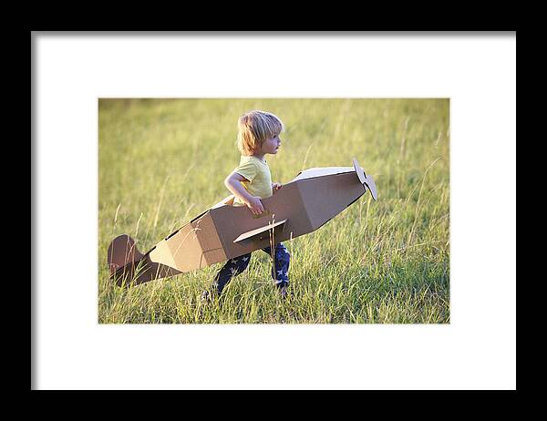 Grass Framed Print featuring the photograph Boy flying airplane outdoors by Ghislain & Marie David de Lossy