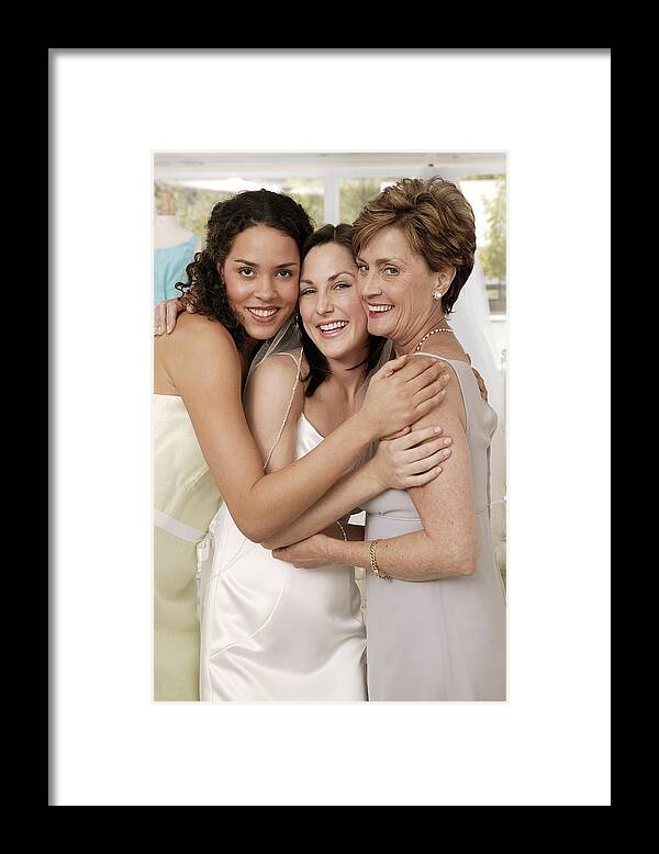 Standing Framed Print featuring the photograph Bridesmaid and mother hugging bride by Comstock Images