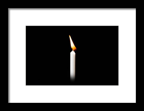 Celebration Framed Print featuring the photograph Burning white candle on black background by Villagemoon