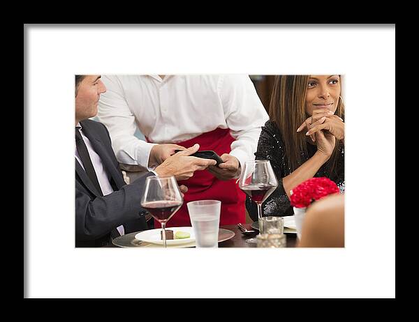 Finance And Economy Framed Print featuring the photograph Businessman paying check at restaurant by Ariel Skelley