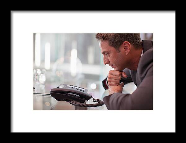 People Framed Print featuring the photograph Businessman staring at telephone waiting for it to ring by Paul Bradbury