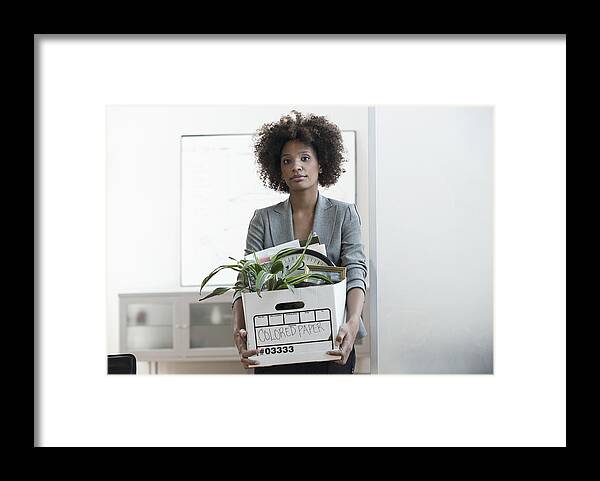 Problems Framed Print featuring the photograph Businesswoman packing up box in office by Image Source RF/Cadalpe