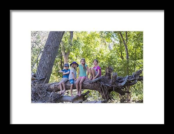 4-5 Years Framed Print featuring the photograph Caucasian children sitting on tree root in forest by Marc Romanelli
