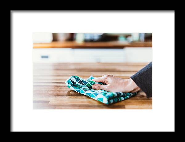 Working Framed Print featuring the photograph Close-up of woman hand cleaning the surface of a table with a cleaning cloth at home by Photographer, Basak Gurbuz Derman