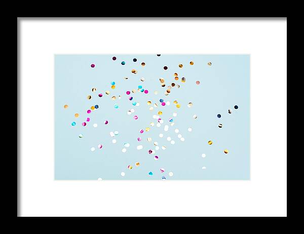 Event Framed Print featuring the photograph Colored confetti flying in the blue sky. Are small pieces or streamers of paper, mylar, or metallic material which are thrown at parades and celebrations. by Kseniya Ovchinnikova