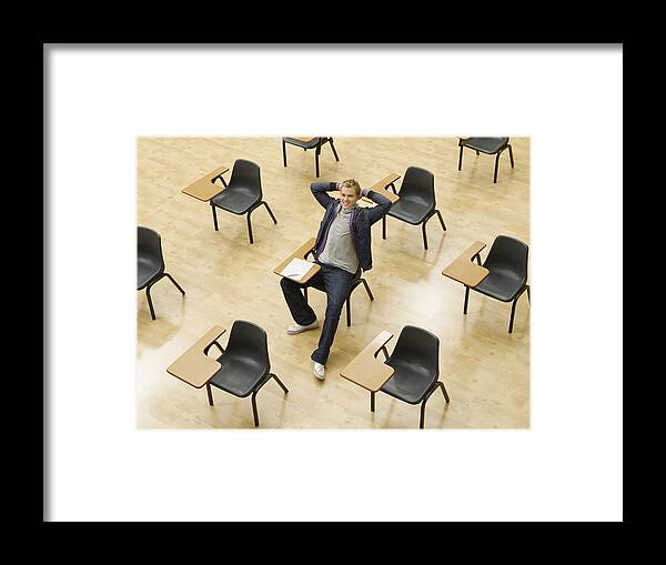 Hands Behind Head Framed Print featuring the photograph Confident college student sitting at desk in classroom by Chris Ryan