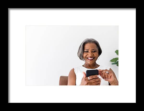 Internet Framed Print featuring the photograph Confident woman laughs while using smartphone by SDI Productions
