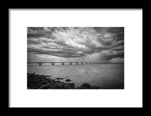 Dark Clouds Framed Print featuring the photograph Dark clouds Zeeland Bridge in black and white by Marjolein Van Middelkoop