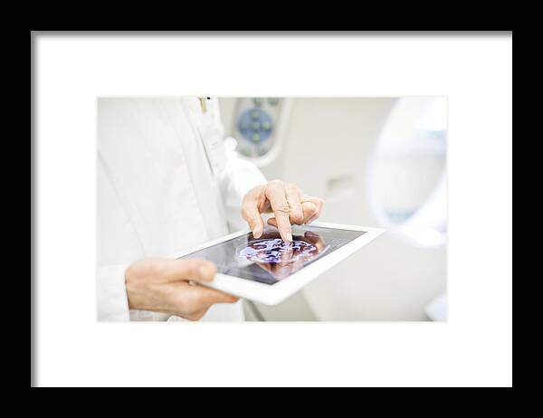 Expertise Framed Print featuring the photograph Doctor analyzing X-ray image in digital tablet by Alvarez