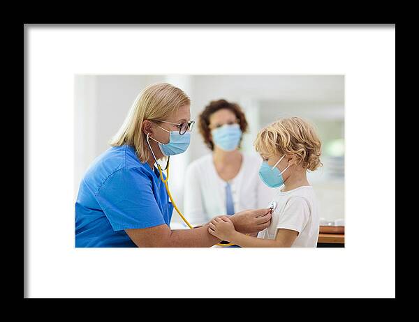 White People Framed Print featuring the photograph Doctor examining sick child in face mask by FamVeld