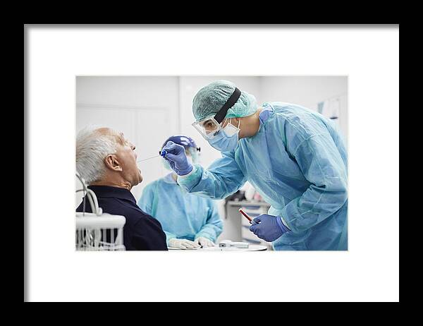 Expertise Framed Print featuring the photograph Doctor Taking Throat Swab Test From Male Patient, PCR by Morsa Images