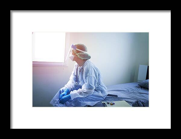 Expertise Framed Print featuring the photograph Doctor wearing PPE (Personal Protection Equipment ) or Isolation grown Suite feeling down and sad for fighting covid-19 (Corona virus) by Skaman306