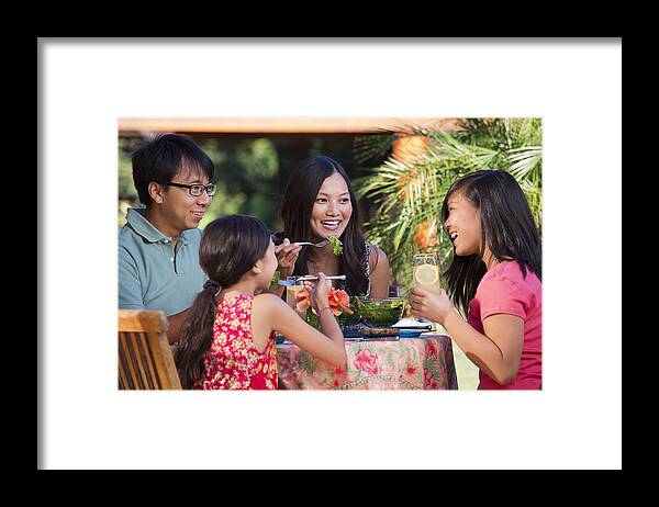 35-39 Years Framed Print featuring the photograph Family eating together on patio by Ariel Skelley