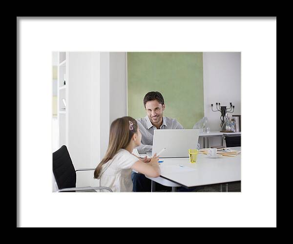 Internet Framed Print featuring the photograph Father working at table while daughter draws by Tom Merton